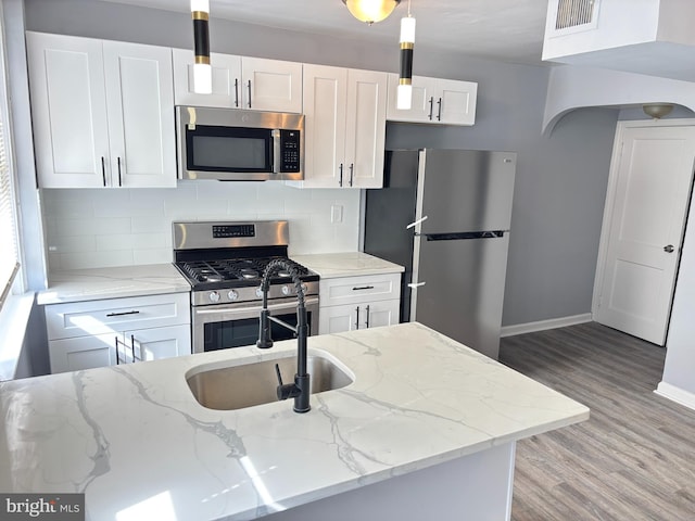kitchen with white cabinets, light wood-type flooring, baseboards, visible vents, and appliances with stainless steel finishes