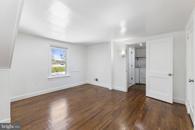 unfurnished bedroom with wood-type flooring, washer and clothes dryer, baseboards, and visible vents