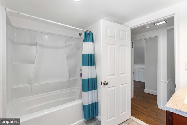 full bathroom featuring vanity, baseboards, wood finished floors, and shower / tub combo with curtain