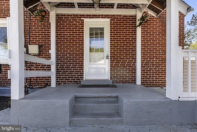 doorway to property with brick siding