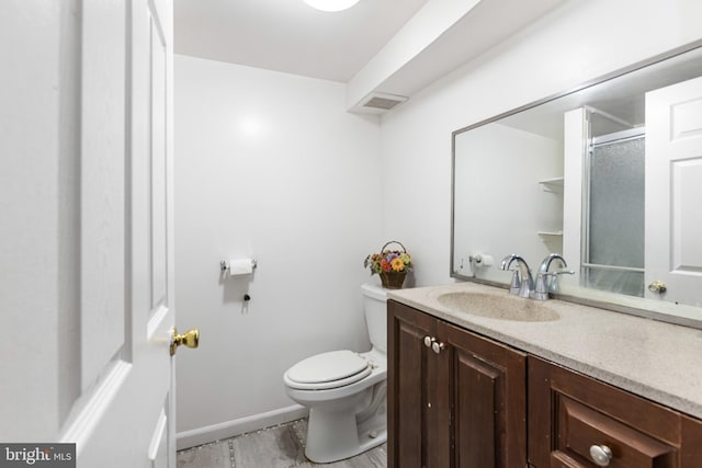 bathroom with vanity, baseboards, toilet, and visible vents
