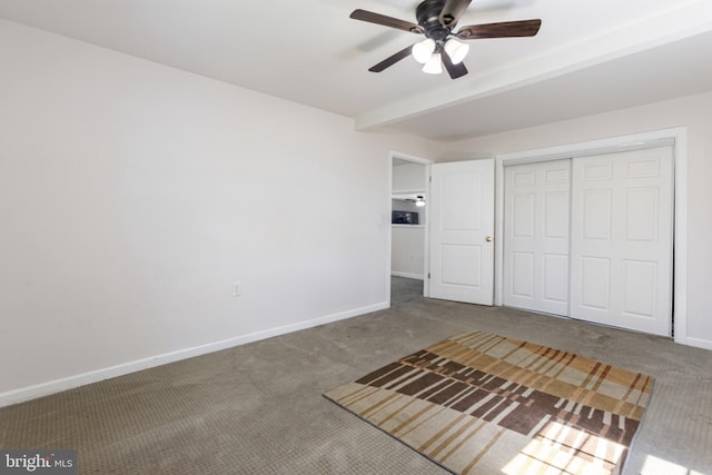 unfurnished bedroom with baseboards, carpet flooring, ceiling fan, and a closet