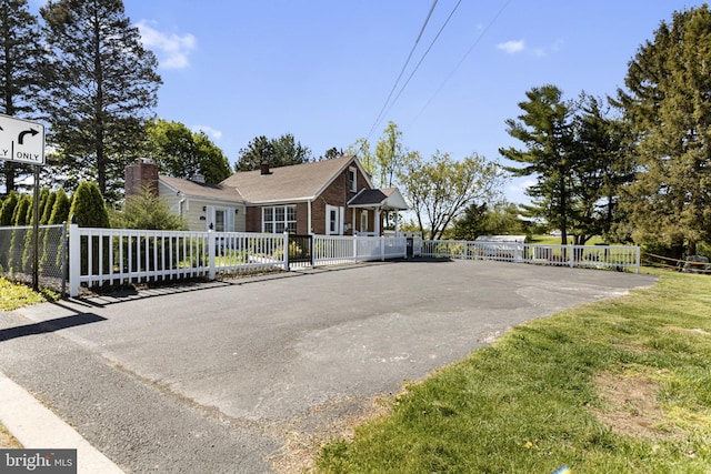 view of front of house featuring brick siding and fence
