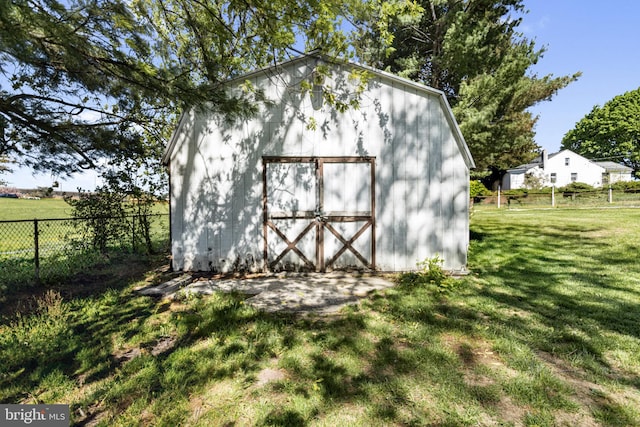 view of outbuilding featuring fence and an outbuilding