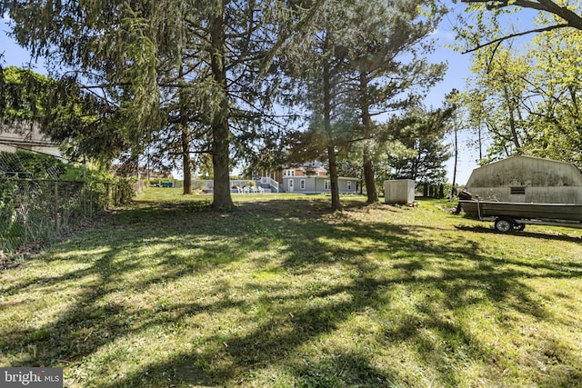 view of yard with fence and an outbuilding