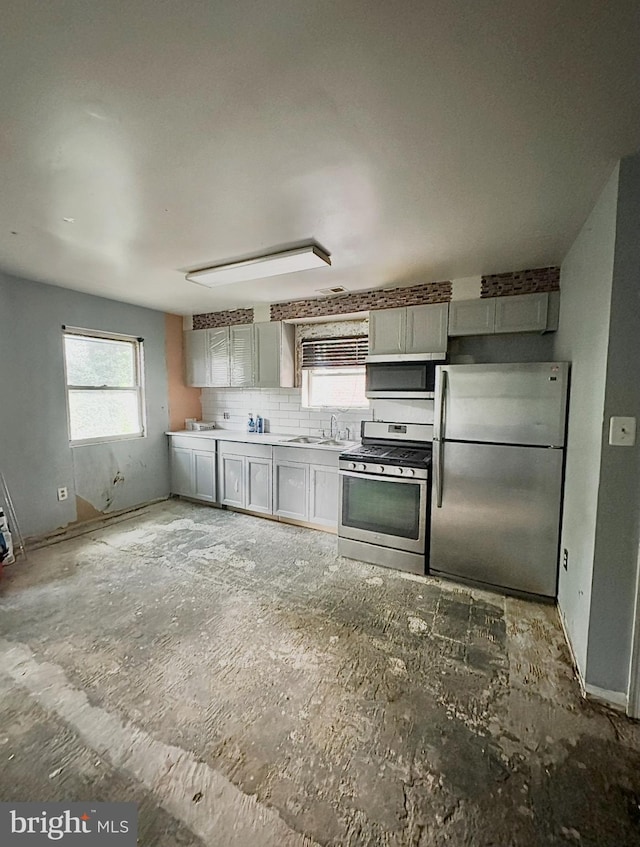 316 Atlantic St SE, Washington, DC 20032 - kitchen featuring a sink, backsplash, light countertops, and appliances with stainless steel finishes