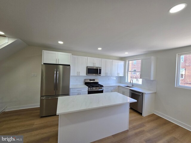 1055 E Cheltenham Ave, Philadelphia, PA 19124 - kitchen with a center island, a sink, decorative backsplash, white cabinets, and appliances with stainless steel finishes