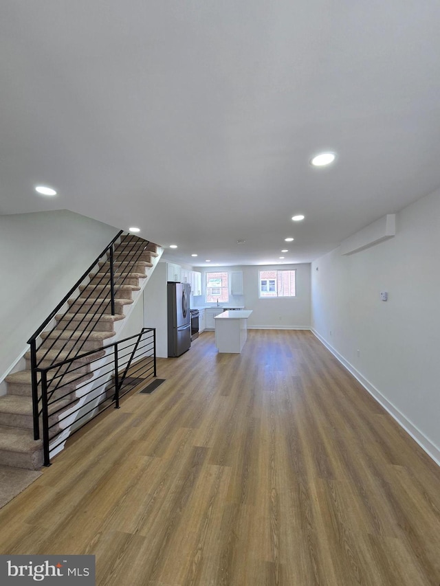 1055 E Cheltenham Ave, Philadelphia, PA 19124 - unfurnished living room with recessed lighting, light wood-type flooring, baseboards, and stairs