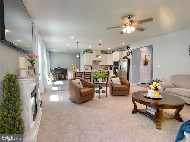 living area featuring ceiling fan and light carpet