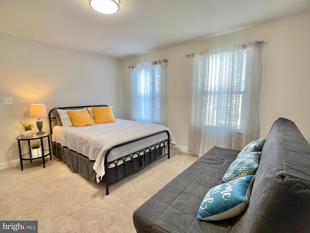 bedroom with light carpet and baseboards