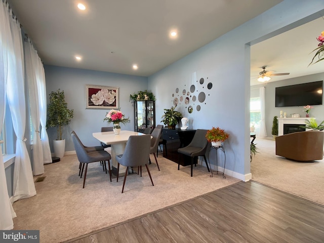 dining space featuring recessed lighting, wood finished floors, ceiling fan, a fireplace, and baseboards