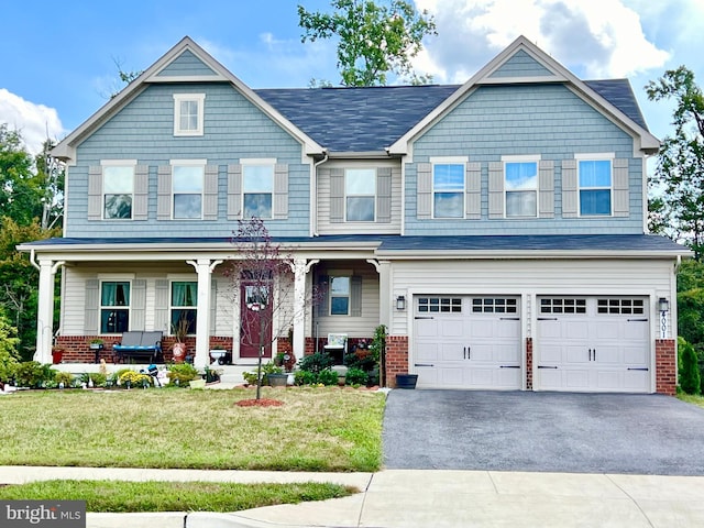 craftsman-style home featuring driveway, an attached garage, covered porch, and brick siding