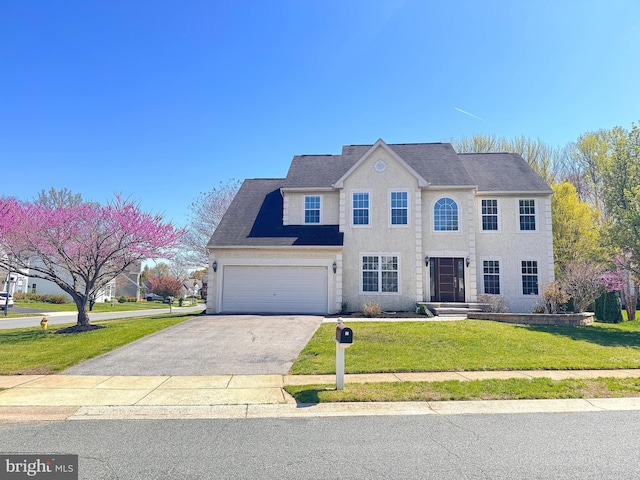 1 Donegal, Newark, DE 19702 - view of front of home featuring stucco siding, a front lawn, and aphalt driveway