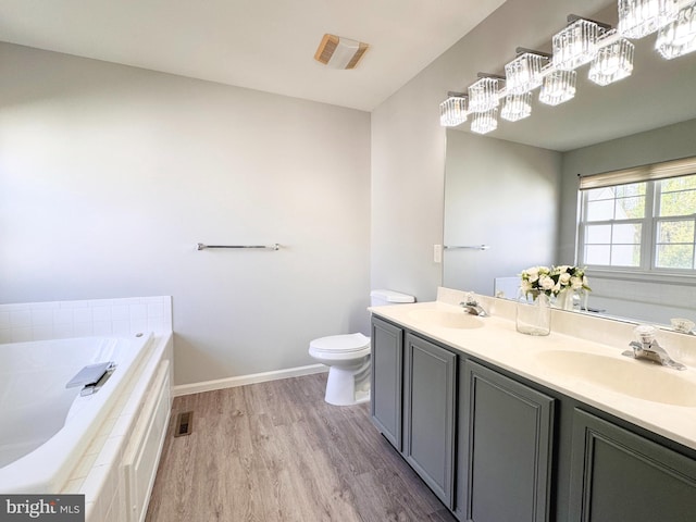 1 Donegal, Newark, DE 19702 - bathroom featuring wood finished floors, toilet, a garden tub, and a sink