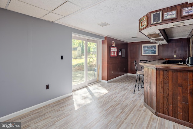12910 Mayflower Ln, Bowie, MD 20720 - bar featuring baseboards, light wood-type flooring, wooden walls, and a dry bar