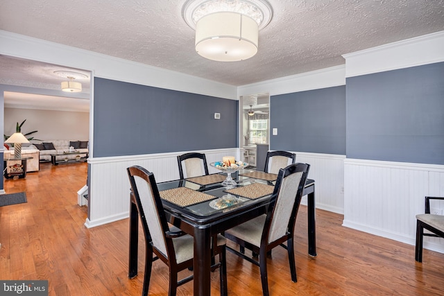 12910 Mayflower Ln, Bowie, MD 20720 - dining space featuring wainscoting, wood finished floors, and a textured ceiling