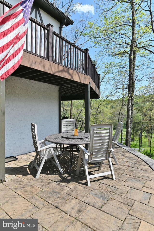 view of patio with outdoor dining area and a balcony