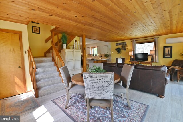 dining area with light wood-style flooring, stairs, a wall mounted AC, and wooden ceiling