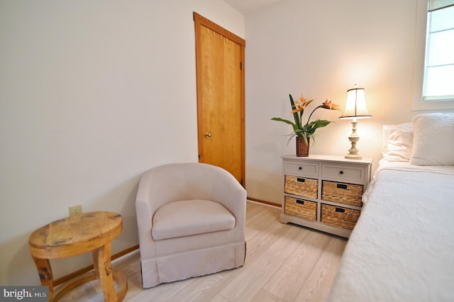 living area featuring baseboards and light wood finished floors