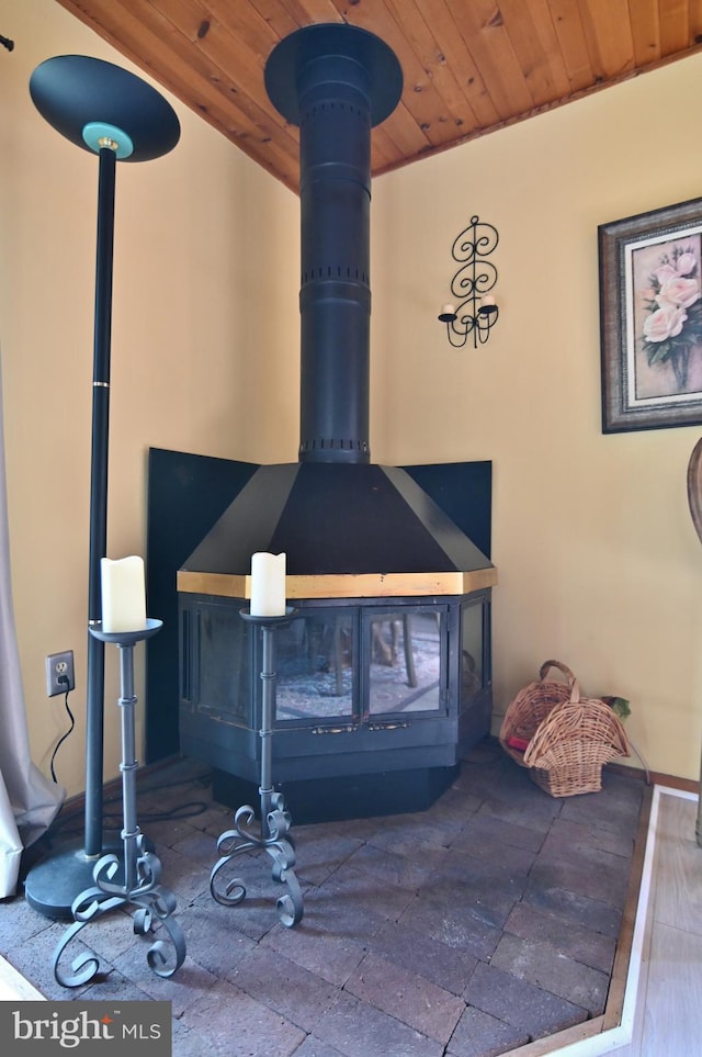 details featuring wooden ceiling and a wood stove