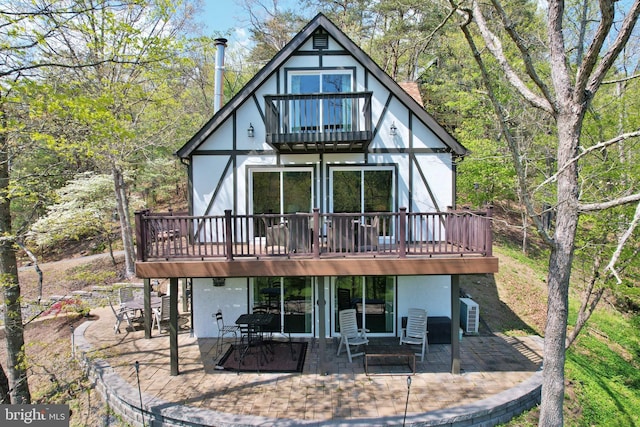 back of house with a deck, a balcony, and a patio area