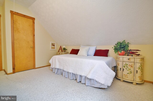 carpeted bedroom with a textured ceiling, baseboards, and lofted ceiling