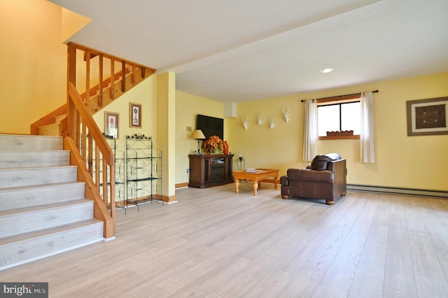 sitting room featuring wood finished floors, baseboards, a baseboard heating unit, and stairway