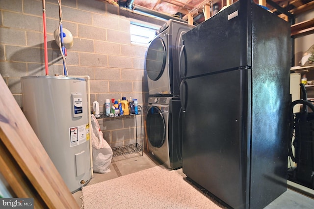 washroom featuring concrete block wall, laundry area, stacked washing maching and dryer, and water heater