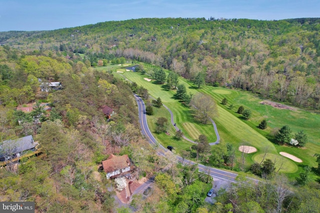 birds eye view of property with view of golf course and a wooded view