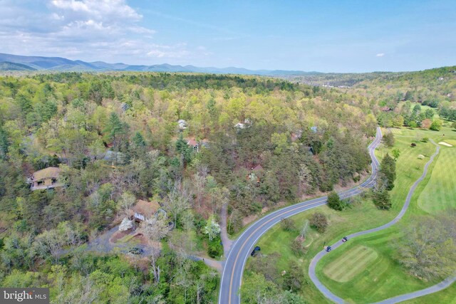 drone / aerial view with a wooded view and a mountain view