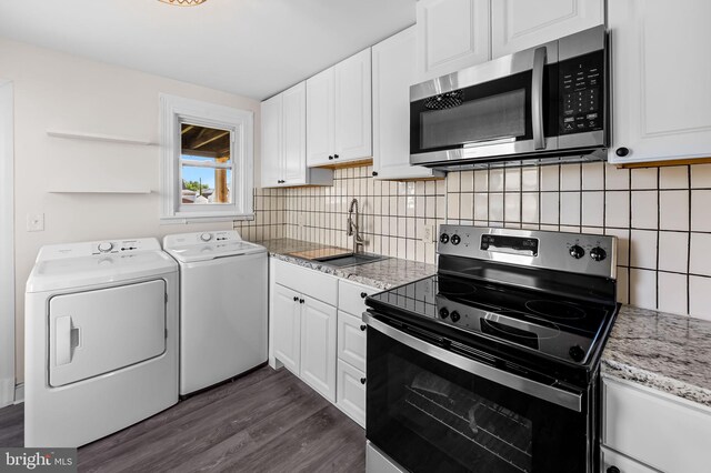 18 Crafton Rd, Baltimore, MD 21221 - kitchen with washing machine and dryer, a sink, dark wood-style floors, stainless steel appliances, and white cabinetry