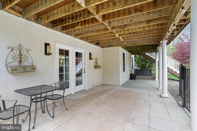 view of patio featuring stairway and a jacuzzi