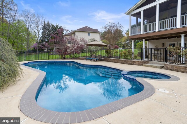 view of pool featuring a pool with connected hot tub, a fenced backyard, and a patio area