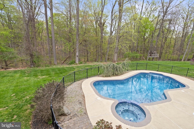 view of pool with a lawn, fence, and a pool with connected hot tub