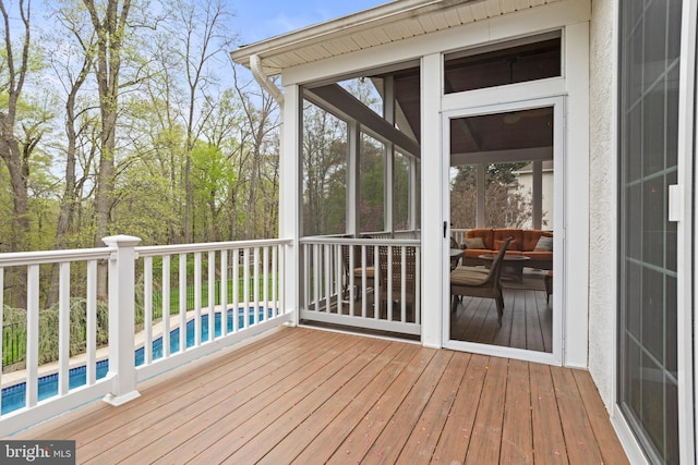 wooden deck featuring a sunroom and an outdoor pool