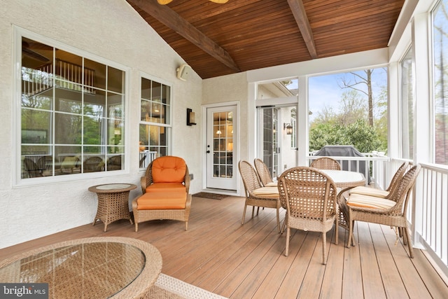 sunroom / solarium featuring beamed ceiling and outdoor dining space