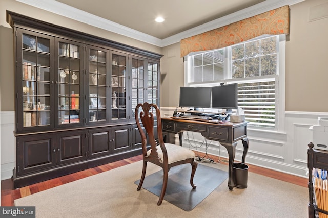 office featuring ornamental molding, wood finished floors, a healthy amount of sunlight, and a wainscoted wall