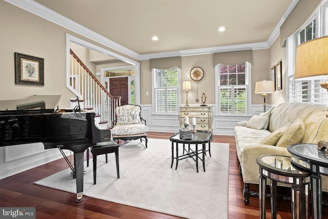 living area featuring stairs, ornamental molding, wood finished floors, and a wainscoted wall