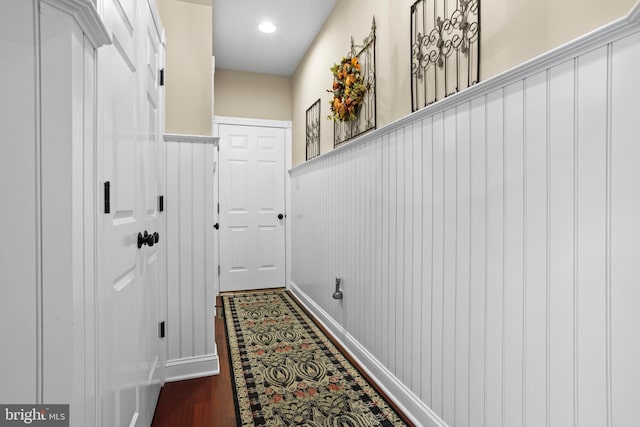 entryway featuring baseboards, dark wood-style flooring, and a wainscoted wall