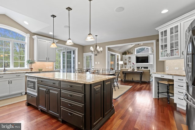 kitchen featuring vaulted ceiling, white cabinets, and stainless steel appliances