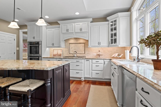 kitchen featuring a sink, appliances with stainless steel finishes, white cabinetry, and a healthy amount of sunlight
