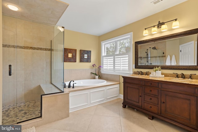 bathroom featuring a shower stall, a sink, tile patterned flooring, and a garden tub