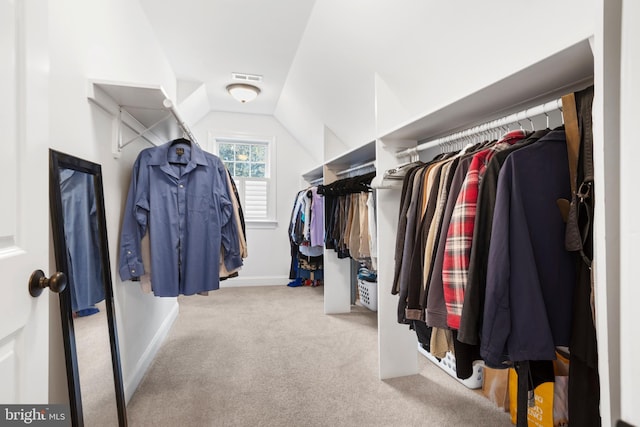 spacious closet featuring carpet, vaulted ceiling, and visible vents