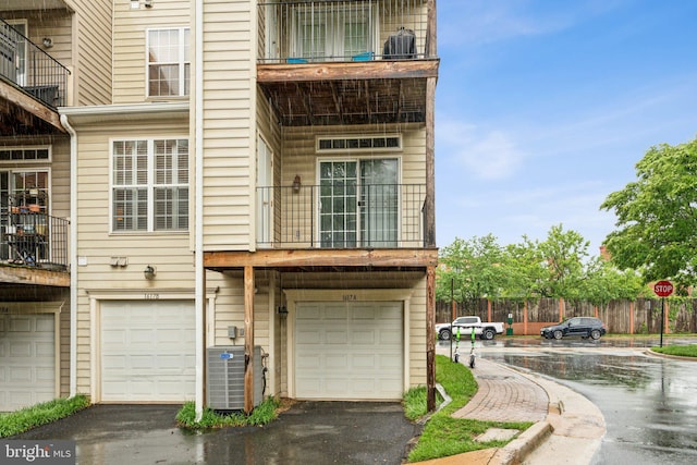 1617 Potomac Greens Dr Unit A, Alexandria, VA 22314 - rear view of property featuring central AC, a garage, a balcony, driveway, and fence