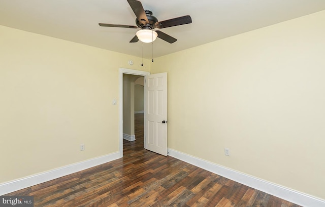 unfurnished room with ceiling fan, baseboards, and dark wood-type flooring