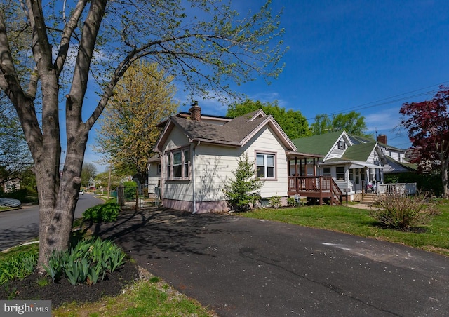 bungalow-style house featuring a porch and a chimney