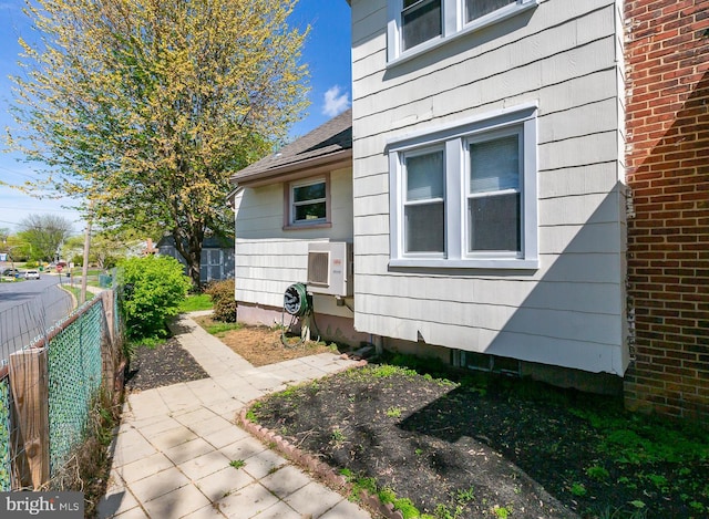 view of side of home with fence and ac unit