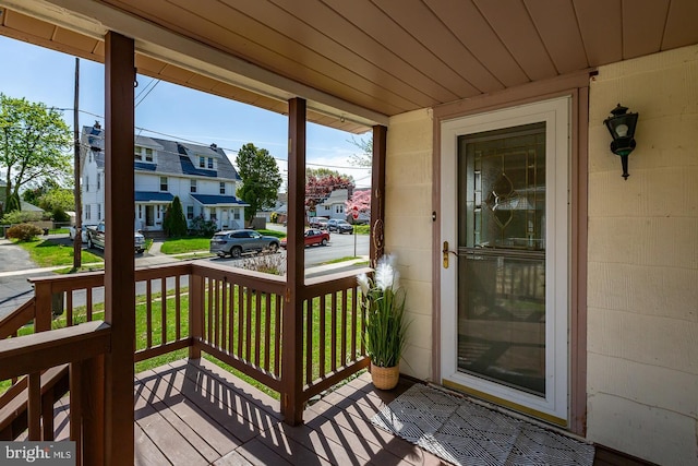view of exterior entry featuring concrete block siding, a residential view, and covered porch