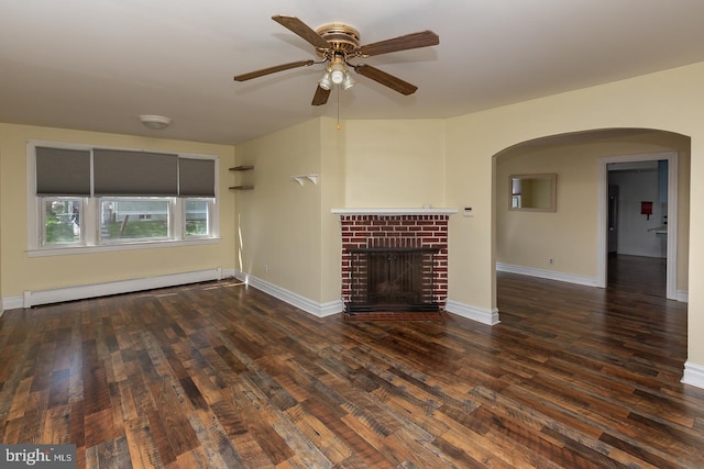 unfurnished living room featuring a baseboard radiator, a ceiling fan, wood finished floors, arched walkways, and a fireplace
