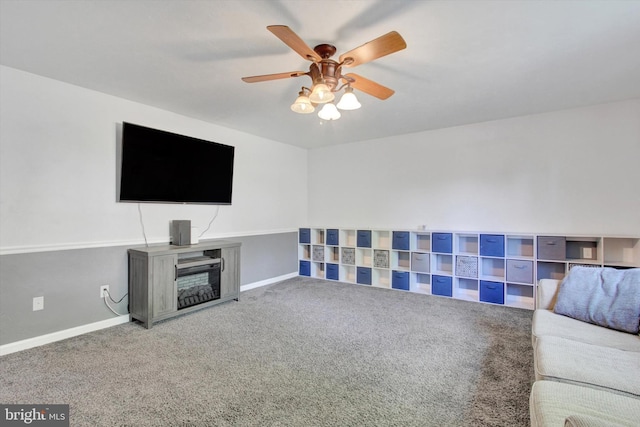 unfurnished living room with carpet flooring, ceiling fan, baseboards, and a fireplace
